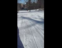 POV of guy sliding on snow on small sled in St. Nicholas park