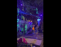 Group of people doing choreograph dance in front of haunted house