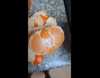 Man peeling mandarin with tiny one inside