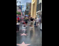 Two women tiktok dance at Hollywood sidewalk