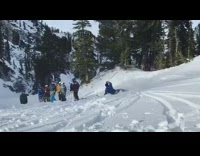 Skier backflips off ramp and falls down in snow, gets up and shakes fist