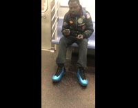 Collab Subway Creatures - Man blue shoes packs a blunt and smokes weed on subway train