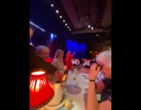 Woman red dress selfie video near stage