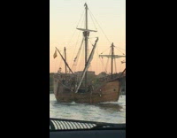 Pirate ship sails in river next to traffic highway