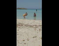 Woman pink bikini bend over pose beach