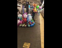 2 guys carry tons of balloons onto train 