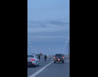 People on small motorcycle ride on the freeway