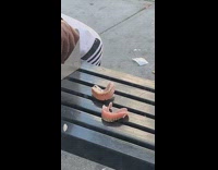 Man at bus stop next to two dentures on bench