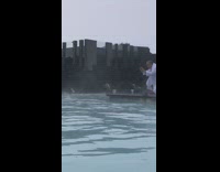 man in robe takes photo of woman