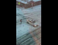 Guy pushes car stuck in snow street