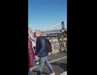 woman yellow jumper brooklyn bridge