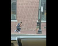 Girl lean pole ask phone red wall