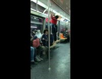 Woman stands on seat and touches advertisement signs on subway train