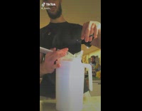 Guy cuts edge of plastic bag like hair 