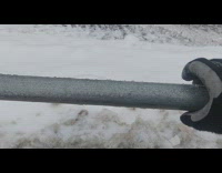 Person rotate and push ice formed on pipe