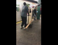 Collab Subway Creatures - guy trying to load big large piece of wood on cart onto subway train