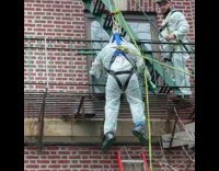 Construction Man Hangs in the Air to Paint in Harness 