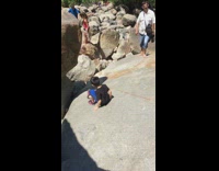 Woman slips off boulder and falls on her back onto rocks
