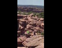 Black shirt guy climbs rock on canyon 