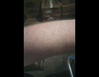 Guy standing in freezer blows on arm 