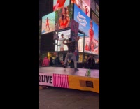 Man floral top dances Time Square stage