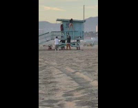 Guy throws money girl dances lifeguard tower 