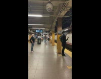 Guy waiting for subway wears star wars costume helmet 