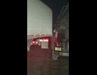 Semitruck turns hits parked car 