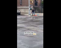 Guy uses broom push water towards drain