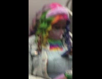 Girl wears rainbow wig on train