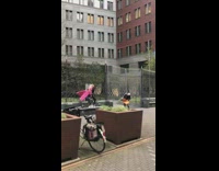 Woman pink coat handbag railings windy pictorial