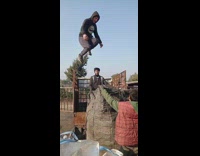 Guy jumps from a truck  into a huge sack 