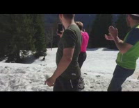 Guy in tshirt and shorts jumps off ramp and falls off skis 