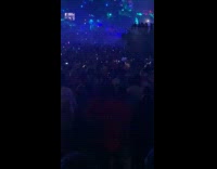 Man stares at phone while at concert