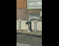 Googly eyes on broken black fire hydrant 