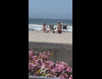 Woman red bikini kneel pose on beach flowers