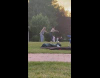 Two women dance wave arms grass sunset