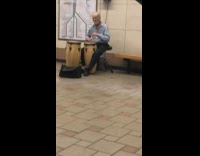 Old man plays bongo drums to R&B song in subway station