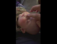 Person softly touch face of sleeping baby