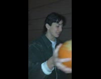 Guy holds split open halved orange pumpkin 