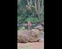 Couple sit on rock river black brief