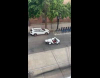 Man drive white three wheeled car street