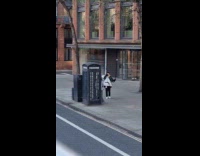 Man with camera and flash near phonebooth