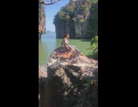 Girl lean back posing on rocks in dress 