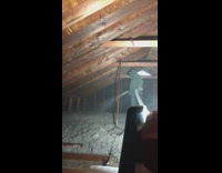 Man is sprays cement on upper level of house 