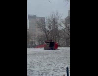 Red crane truck flipped sideways on snow