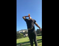 Guy cheers the camera and chugs entire bottle of fireball on grass field