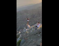 White shirt girl rock edge of mountain 
