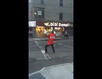 Guy wearing red bottle costume dances crosswalk 