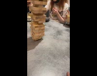 Girl use phone swipe jenga piece slow motion
